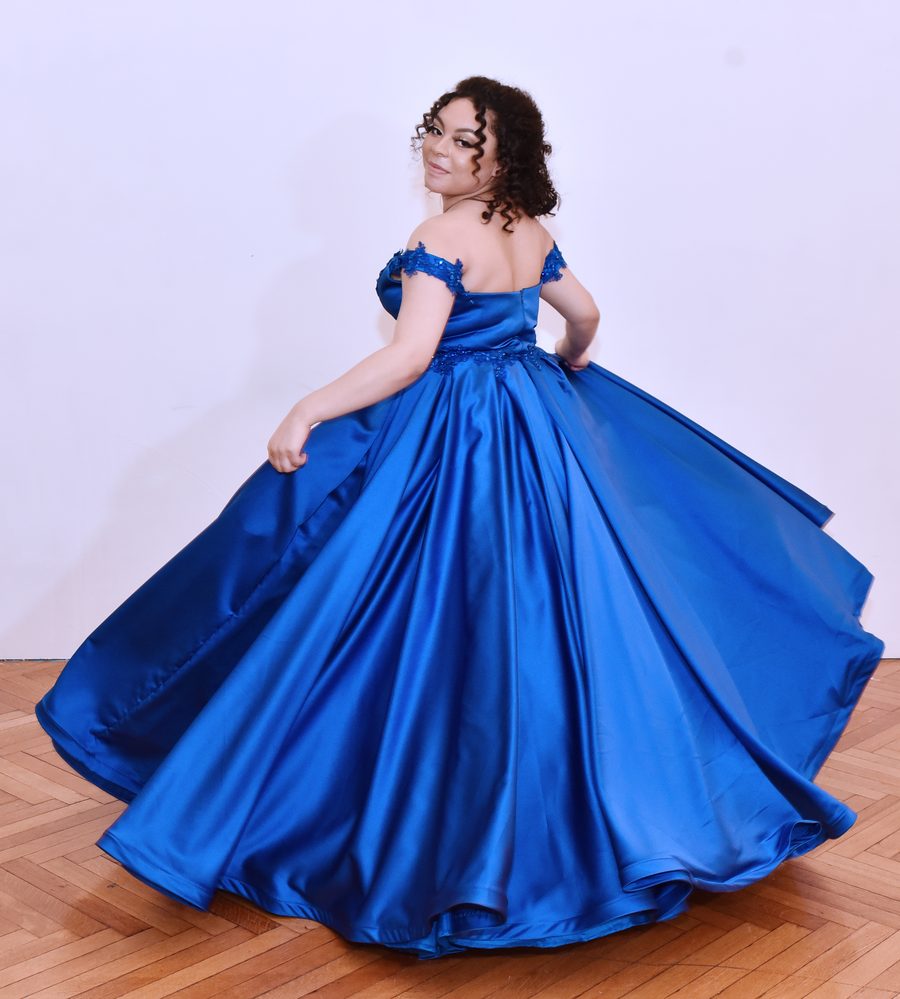 Celebrant twirling in a royal blue satin gown