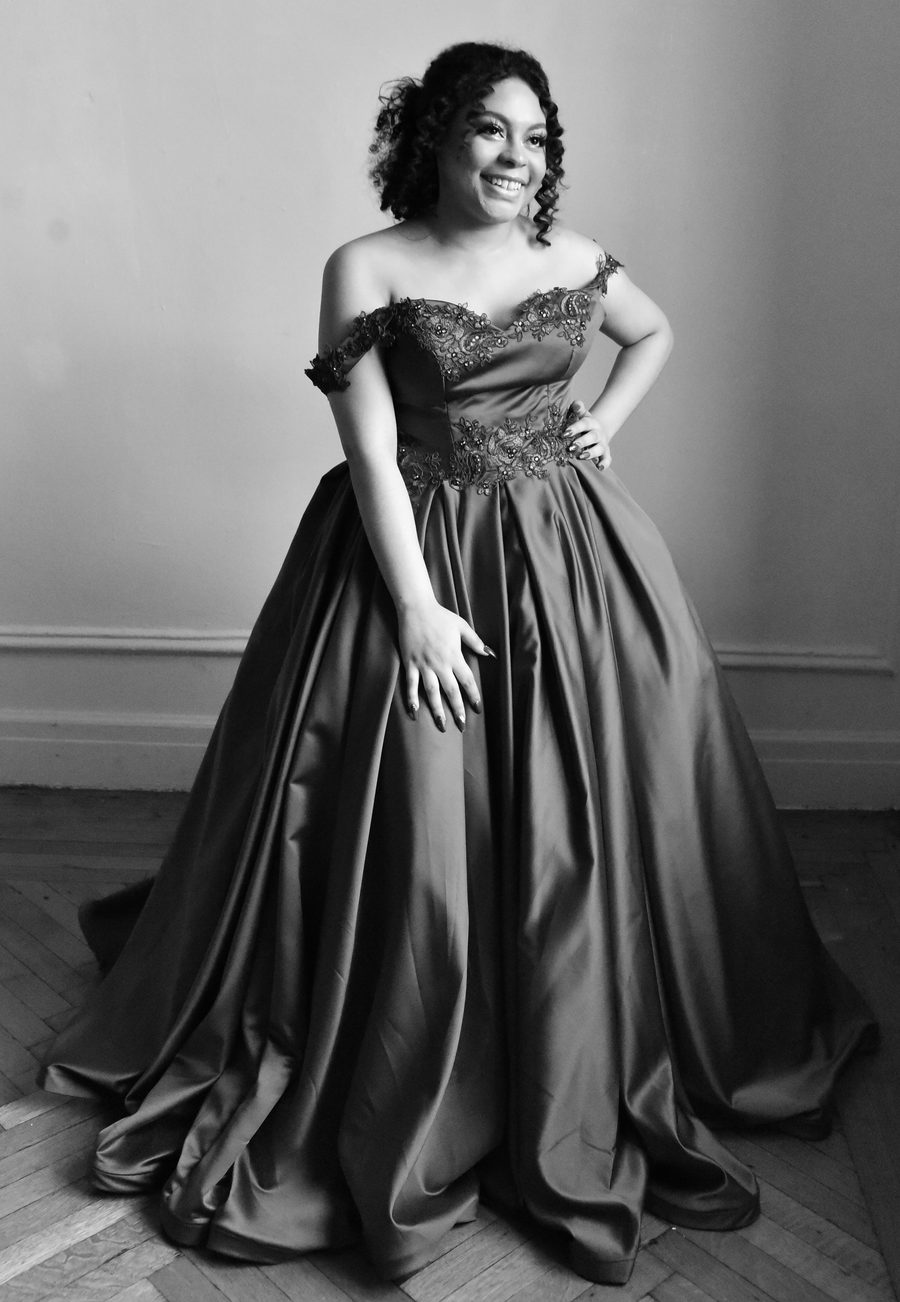 Black and white portrait of a celebrant smiling in a satin ball gown