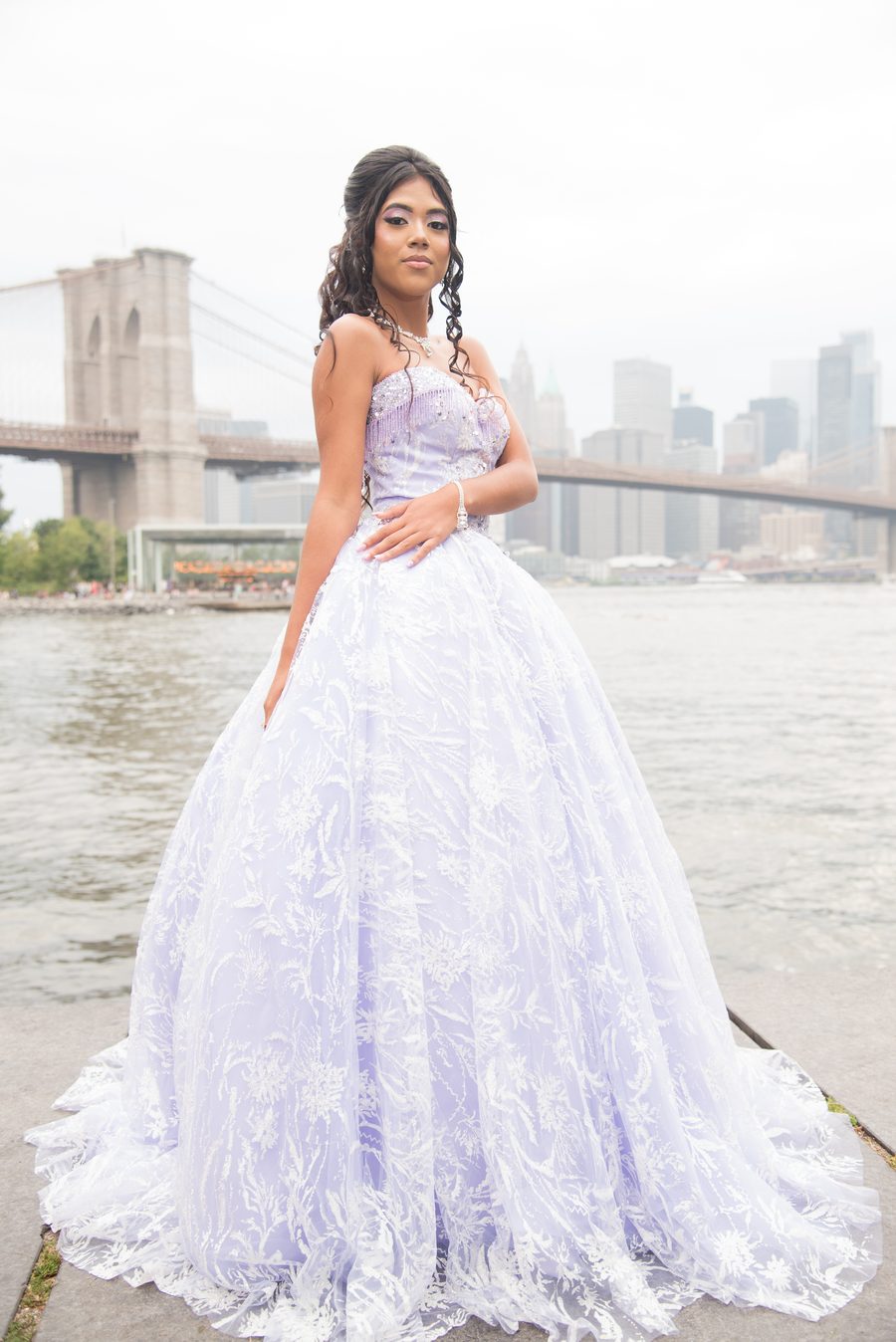 Quinceañera in a lilac ball gown with the Manhattan skyline behind her