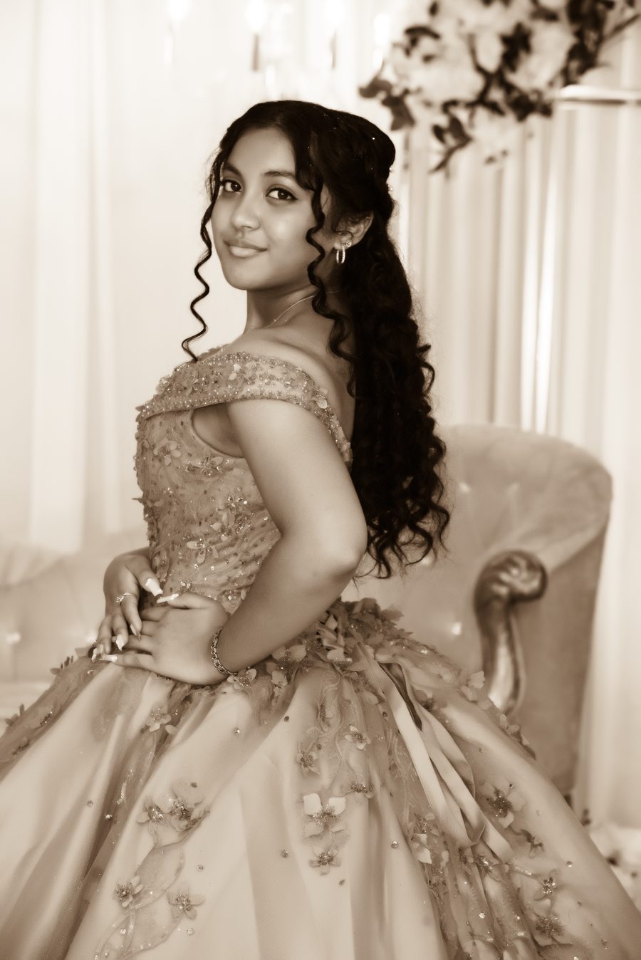 Sepia portrait of a quinceañera in an off-the-shoulder gown