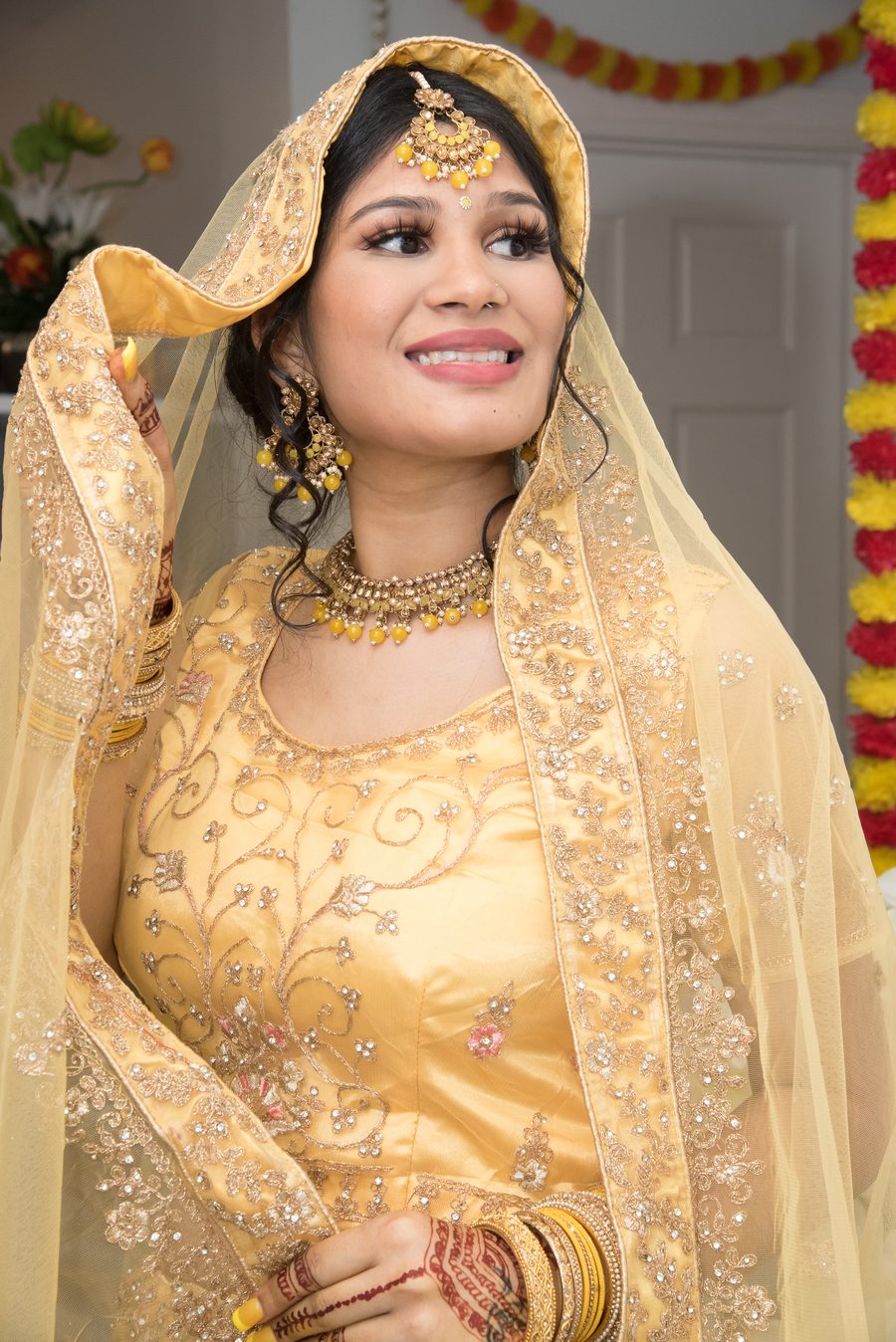 Bride in gold with traditional jewelry smiling