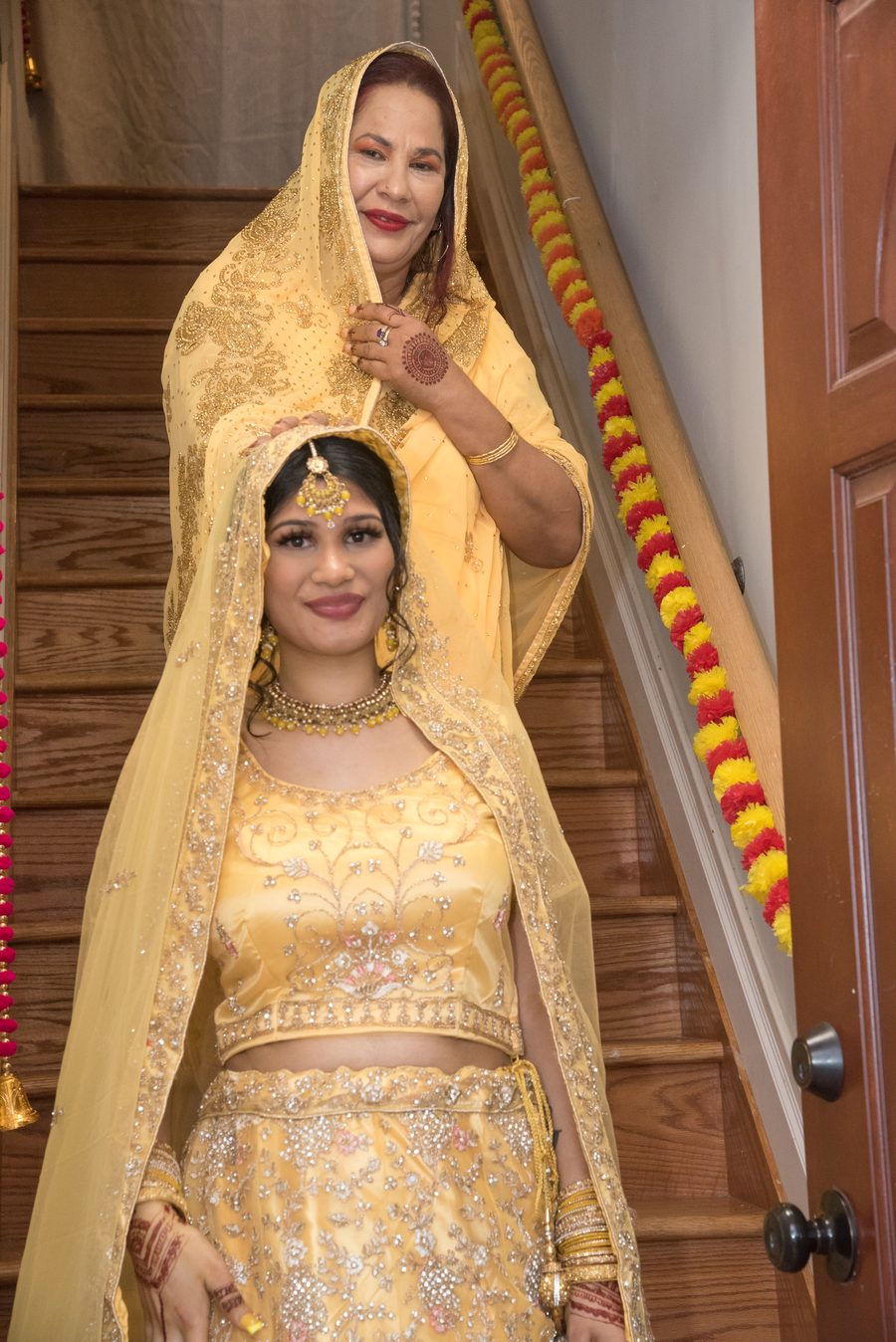 Mother placing the veil over the bride on the staircase